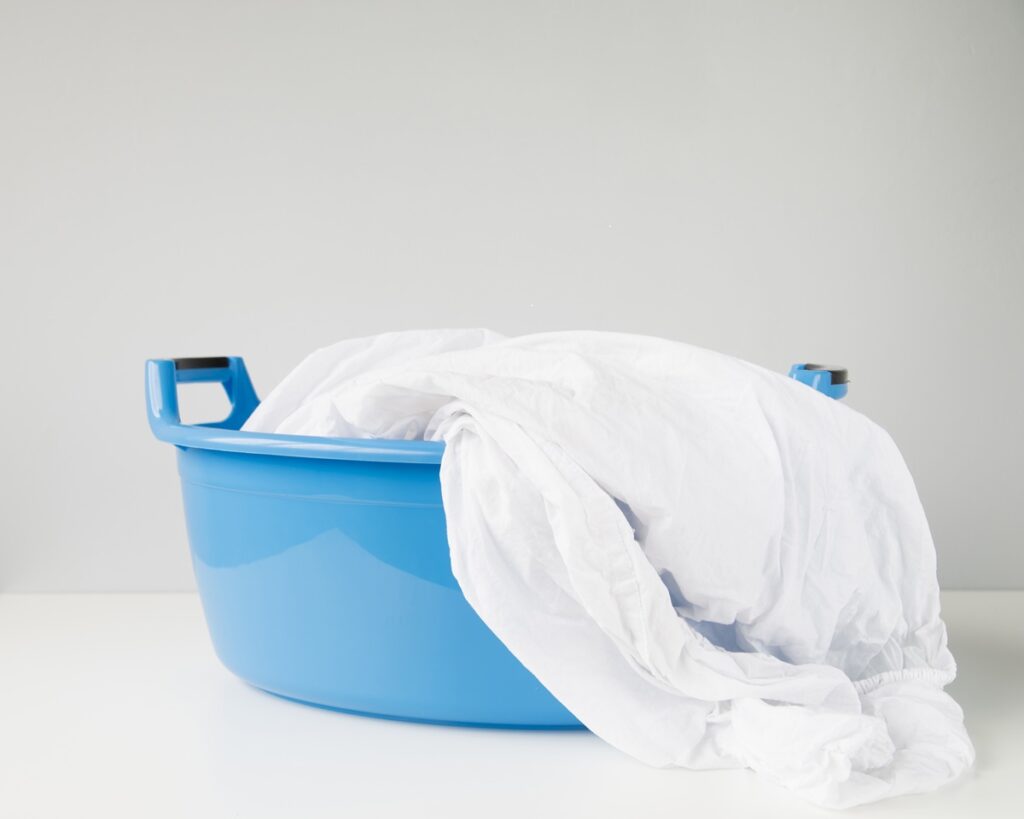 Blue laundry basket with white sheet