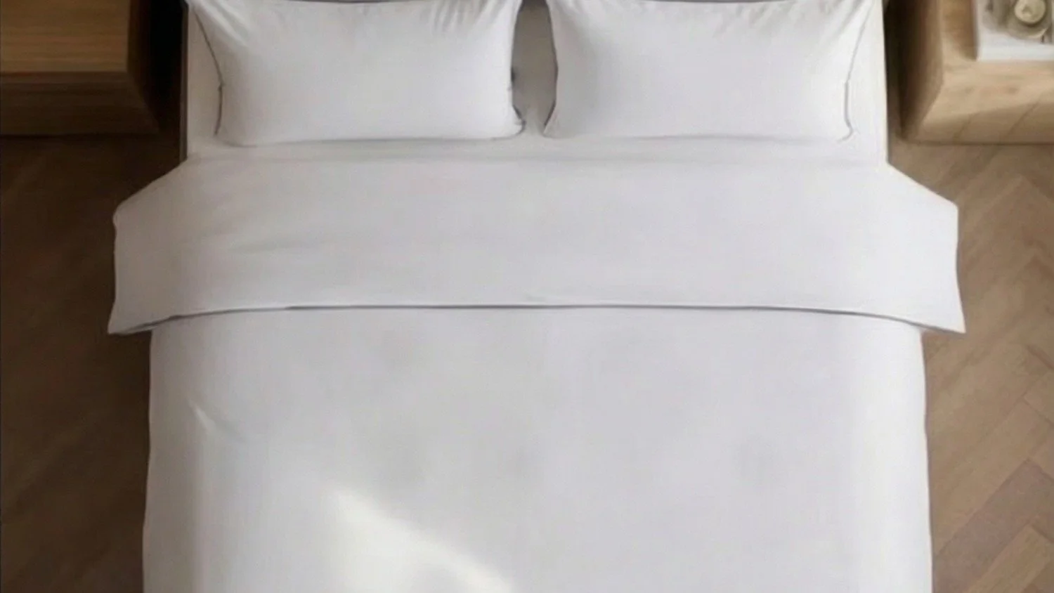White bedding set viewed from above in a modern bedroom